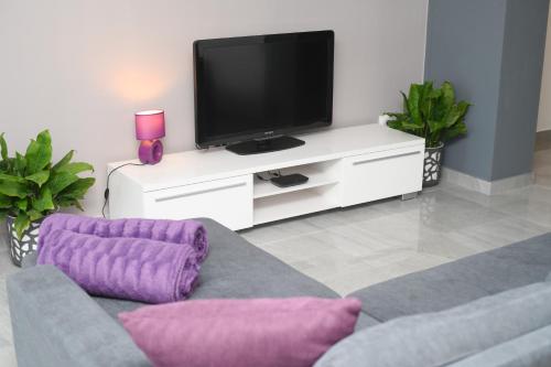 a living room with a tv and a couch at Apartments Lidija - sea view apartment with exclusive right of using hot tub or split level apartment with exclusive right of using pool in Podstrana