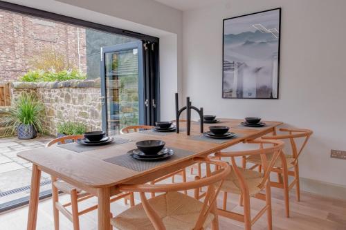 a dining room with a wooden table and chairs at Andrean House, St Andrews in St. Andrews