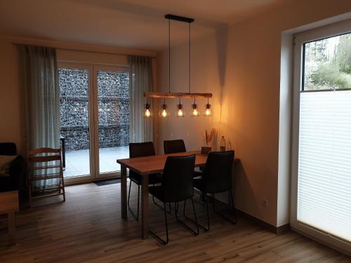 a dining room with a table and chairs and a window at Ferienwohnungen am Aeppelsberg in Volkesfeld