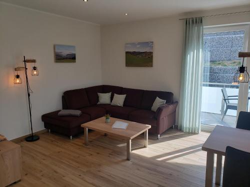 a living room with a couch and a coffee table at Ferienwohnungen am Aeppelsberg in Volkesfeld