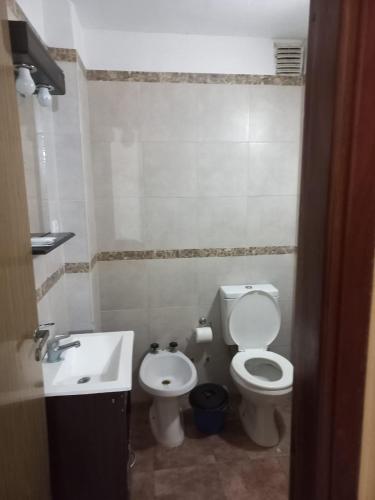 a bathroom with a toilet and a sink at San Remo World Hotel in San Clemente del Tuyú
