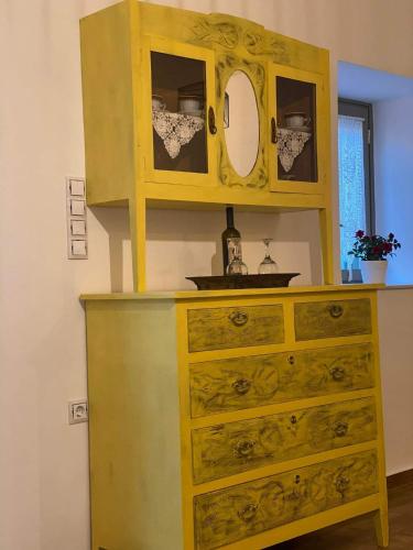 a yellow dresser with a mirror on top of it at FOTIS HOUSE in Koroni