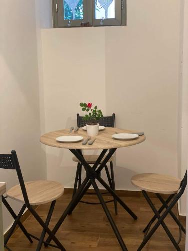 a wooden table with two chairs and a potted plant at FOTIS HOUSE in Koroni