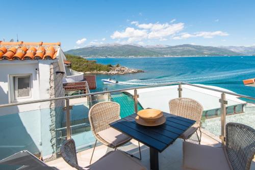 einen Balkon mit einem Tisch, Stühlen und Meerblick in der Unterkunft Casa del Mare Bjelila in Tivat