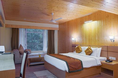 a bedroom with a bed and a desk in a room at Treenz Hotel in Gangtok