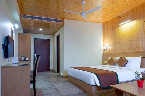 a bedroom with a bed and a desk and a table at Treenz Hotel in Gangtok