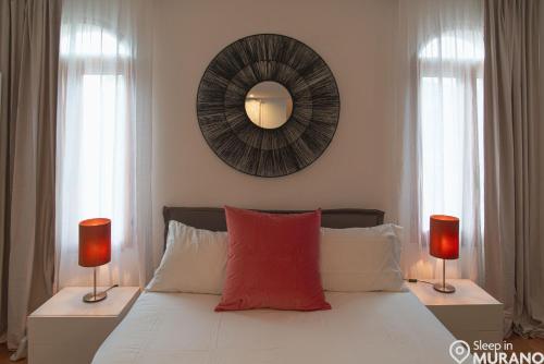 a bedroom with a bed with two lamps and a mirror at MURANO Place - RIVA House in Murano