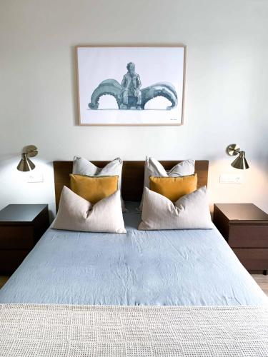 a bedroom with a bed with two lamps and a picture on the wall at Celta Home in Vigo