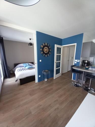 una camera con un letto e un orologio a muro di magnifique appartement 3 étoiles centre ville et mer à pied a Saint-Brévin-les-Pins