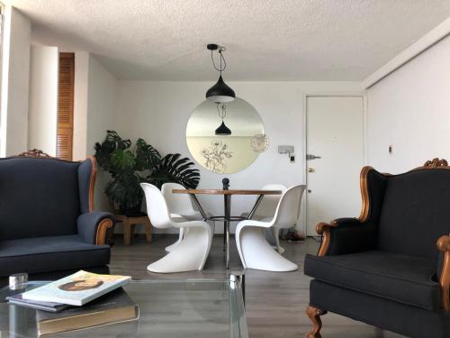 a living room with a table and chairs at Increible departamento en la del valle in Mexico City