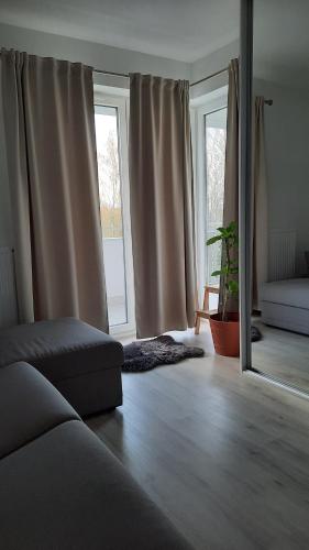 a living room with a couch and two windows at Apartament Widok z tarasami in Ostróda