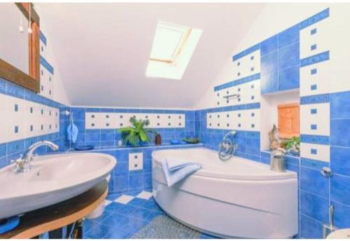 un bagno blu e bianco con vasca e lavandino di HVAR HEART HERITAGE STONE HOUSE 2 floors, up to 6 persons a Stari Grad (Cittavecchia)