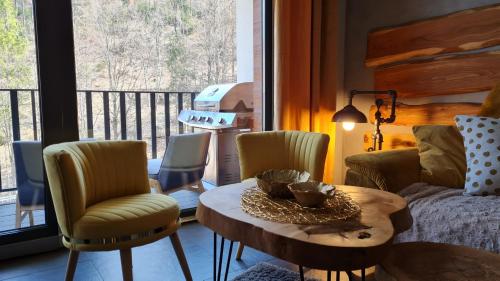 a room with a table and chairs and a balcony at Apartament SPOKOLOKO Wiślańska Złoty B1 in Szczyrk
