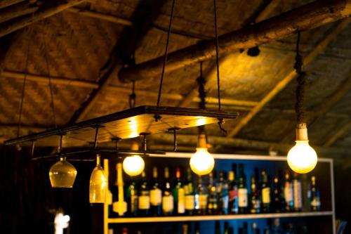 un montón de luces colgando de un bar con botellas en Village Susegat Beach Resort, en Morjim