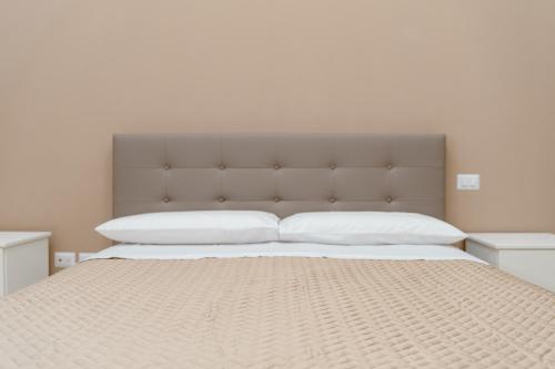 una camera da letto con un letto grande con una grande testiera di Carmela's Guest House Pompeii a Pompei