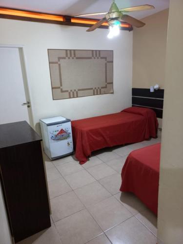 a room with two beds and a tv in it at San Remo World Hotel in San Clemente del Tuyú