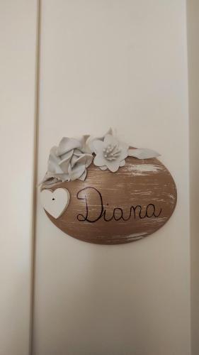 a wooden sign with flowers on top of it at Villa Manto Bed and Breakfast - Torre Annunziata Pompei in Torre Annunziata