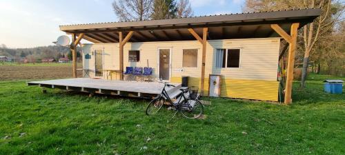 a house with a bike parked in front of it at Domek holenderski święty spokój Bieszczady in Ropienka