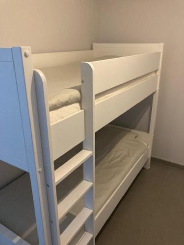 a white bunk bed with a ladder in a room at West-Ende in Middelkerke