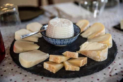 Agriturismo le due querce في Cerreto di Spoleto: طبق من الطعام مع الجبن ووعاء عليه
