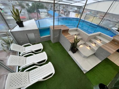 een kamer met stoelen en een zwembad bij Destiny Hotel in Baños