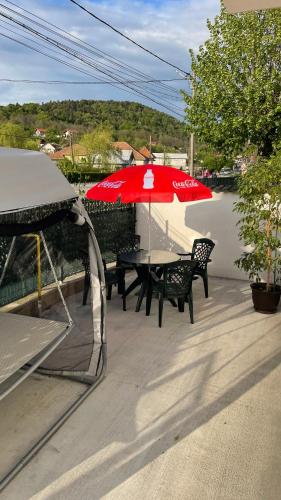 a patio with a table and a red umbrella at Cazare Vila GOG - Rm Valcea-Salina Ocnele Mari in Râmnicu Vâlcea