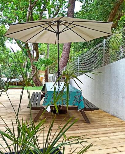 une table et un parasol sur une terrasse dans l'établissement HOSSEGOR LE GARDEN lac et océan à pieds, à Soorts-Hossegor
