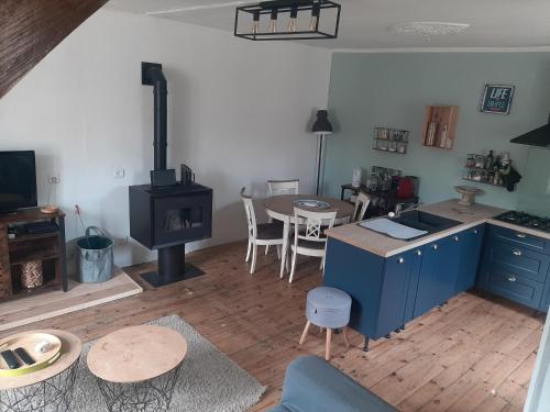 una cucina con mobili blu e un tavolo con fornelli di La maison à la porte bleue a Voutezac