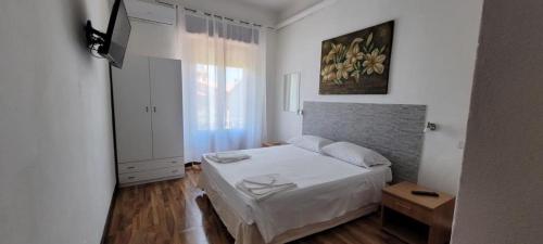 - une chambre avec un lit blanc et une fenêtre dans l'établissement La Mimosa B&B, à Pula