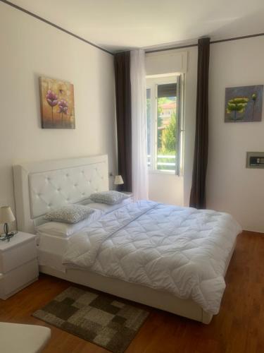 a bedroom with a white bed and a window at Albergo al lago in Anfo