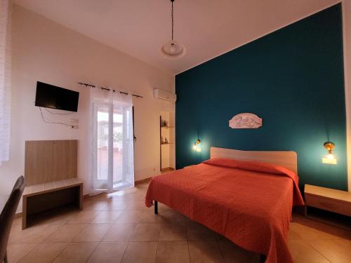 a bedroom with a red bed and a green wall at B&B La Filanda in Scilla