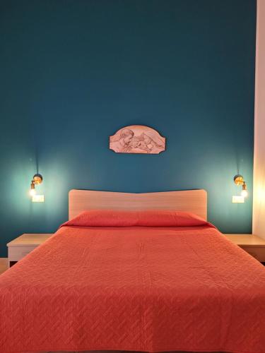 a bedroom with a red bed with a blue wall at B&B La Filanda in Scilla
