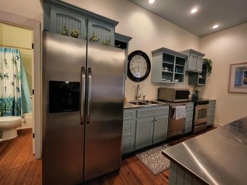 uma cozinha com um frigorífico de aço inoxidável e um relógio em Deer Run Estate LLC em Marshfield