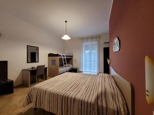 a bedroom with a bed and a desk and a window at B&B La Filanda in Scilla