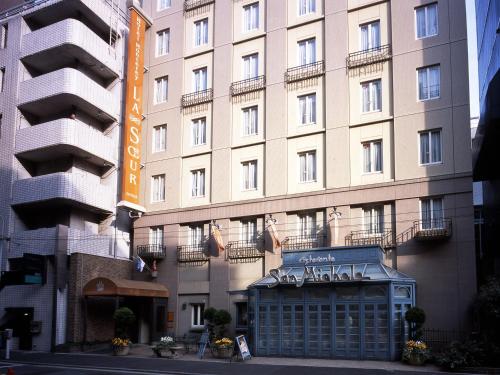 a large building with a sign in front of it at Hotel Monterey Lasoeur Ginza in Tokyo