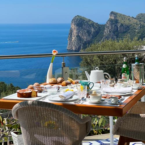 a table with food and a view of the ocean at Quattro Passi Relais in Nerano