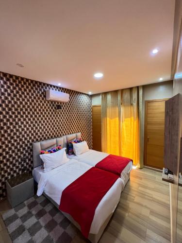 a bedroom with a large bed with red and white pillows at Villa Haitam Marrakech in Oubadine