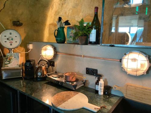 een keuken met een aanrecht met een fornuis en verlichting bij Tesi Eco-suite in Mergelgrot in Riemst
