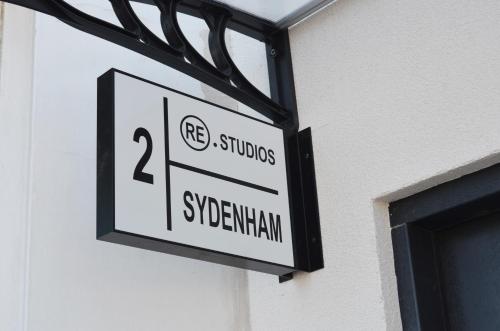 a sign hanging on the side of a building at Lovely Studio Apartment with access for Wheel-chairs in Sydenham in Forest Hill