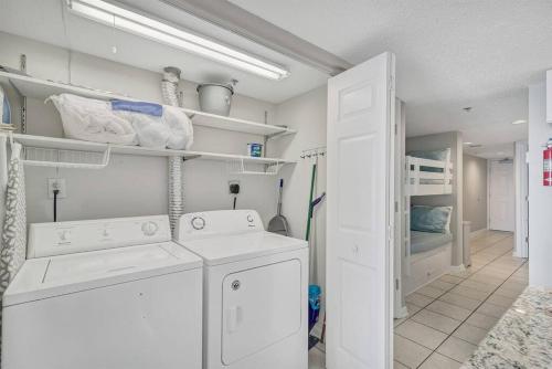 a laundry room with a washing machine and a bunk bed at Fourwinds 803 - Beachfront condo w/ Hall Bunks! - Elevator replacement 4/4-5/24 in Orange Beach