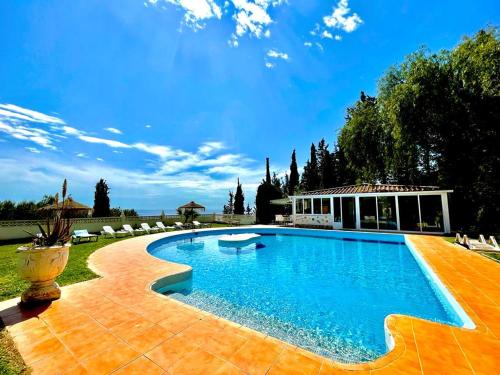 a swimming pool in a yard with chairs and a building at las flores in Almuñécar