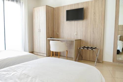 a bedroom with a desk and a tv on a wall at Hotel El Djenina in Tangier