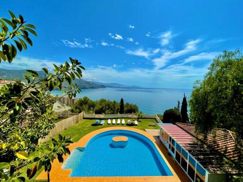 a swimming pool with a view of the water at las flores in Almuñécar