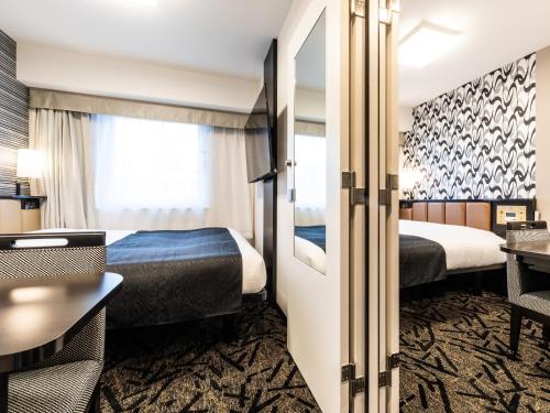 大阪的住宿－APA Hotel Namba Shinsaibashi Higashi，酒店客房配有两张床和一张书桌