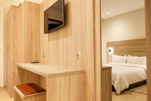 a bedroom with a bed and a tv on a wall at Hotel El Djenina in Tangier