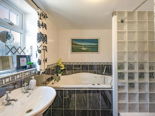 a bathroom with a tub and a sink at Halfen Granary in Llanfihangel-yng-Ngwynfa