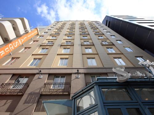 a tall building with a sign in front of it at Hotel Monterey Lasoeur Ginza in Tokyo