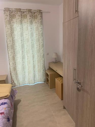 a bedroom with a bed and a window with a curtain at KOS SUITE HOME in Platánion