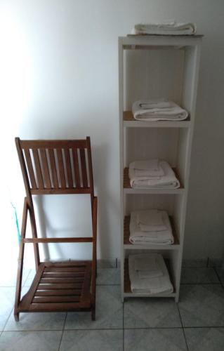 a chair sitting next to a shelf with folded towels at Villaventure in Le Vauclin