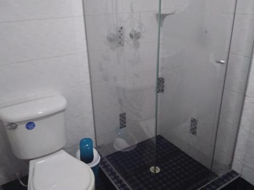 a bathroom with a glass shower with a toilet at Habitación con baño privado cerca al aeropuerto in Bogotá